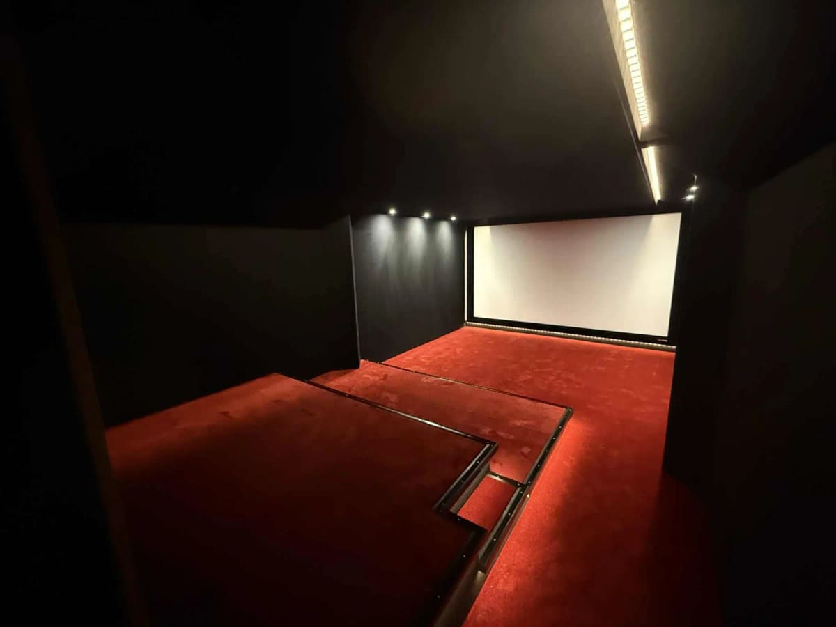 Écran, moquette rouge et éclairage intégrés dans la salle terminée