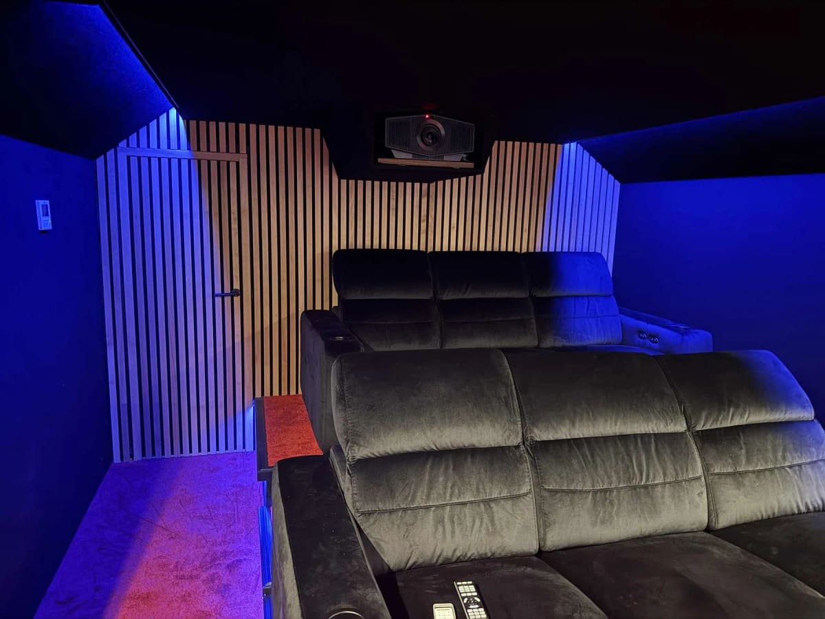 Fauteuils et vidéoprojecteur installés devant les panneaux à tasseaux de bois