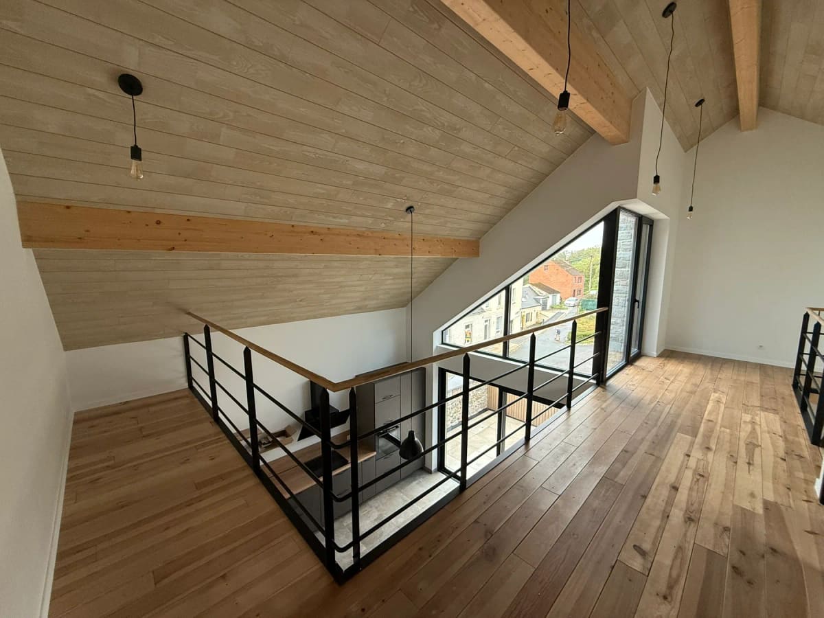 Mezzanine terminée avec plancher bois apparent et garde-corps en métal noir à Merlemont