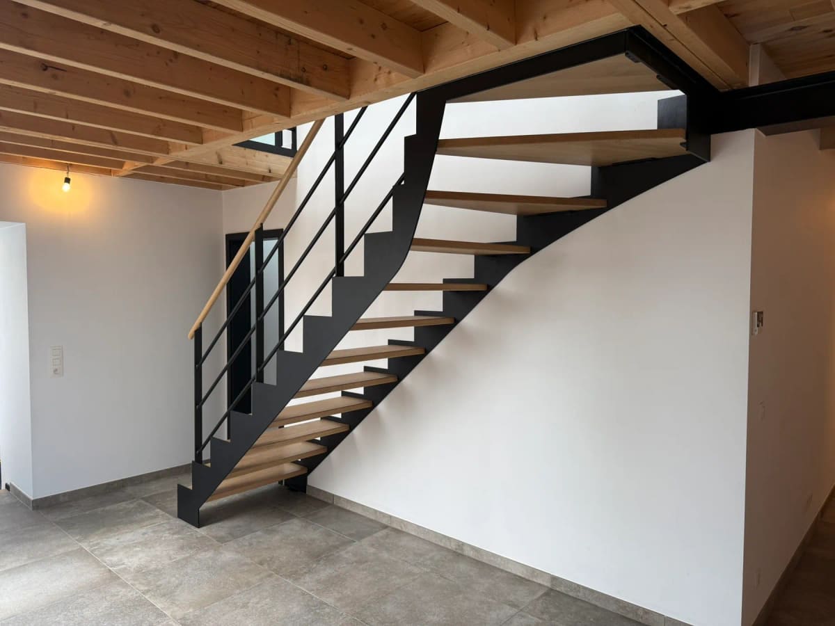 Escalier sur mesure en bois et métal noir dans la grange rénovée